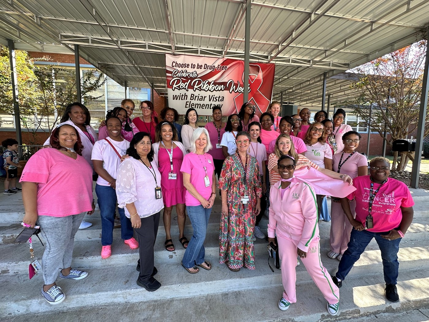 women in pink outfits on school steps