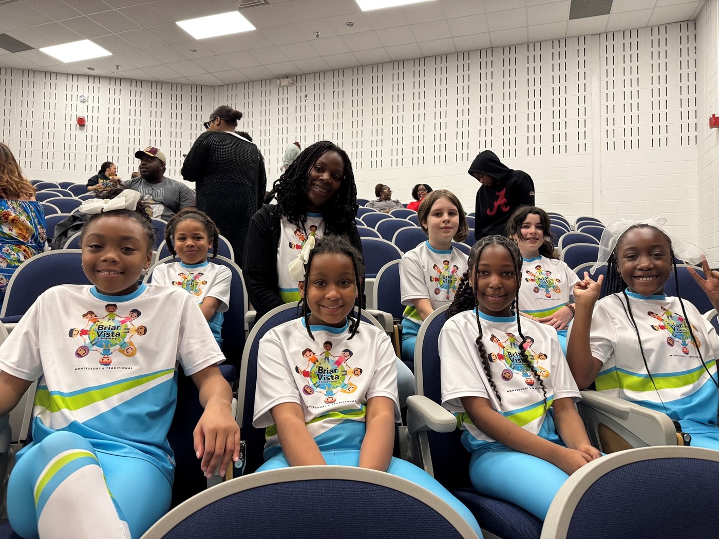 Students in dance uniforms in auditorium